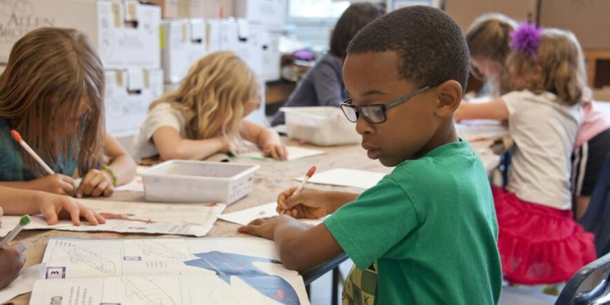 Young children doing homework at a table.