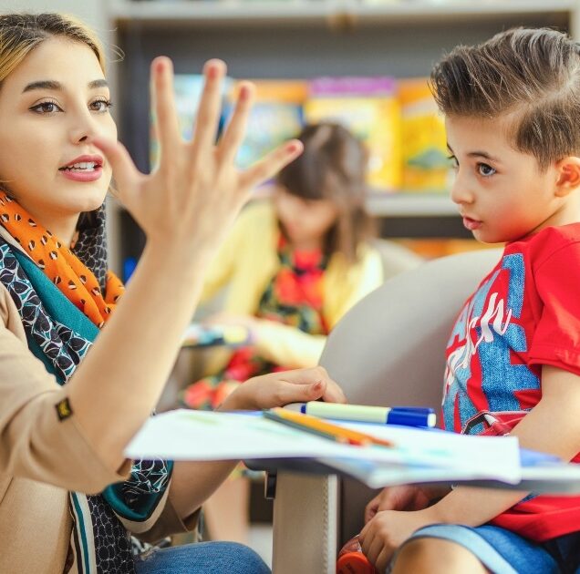 Tacher interacting with child in a classroom