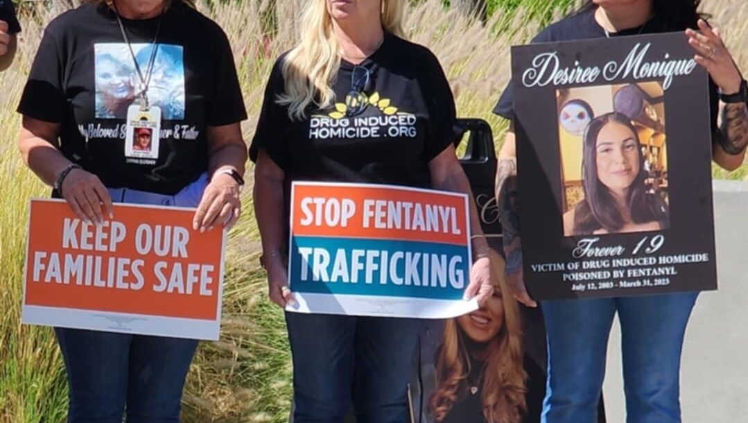 Three women hold signs opposing fentanyl.