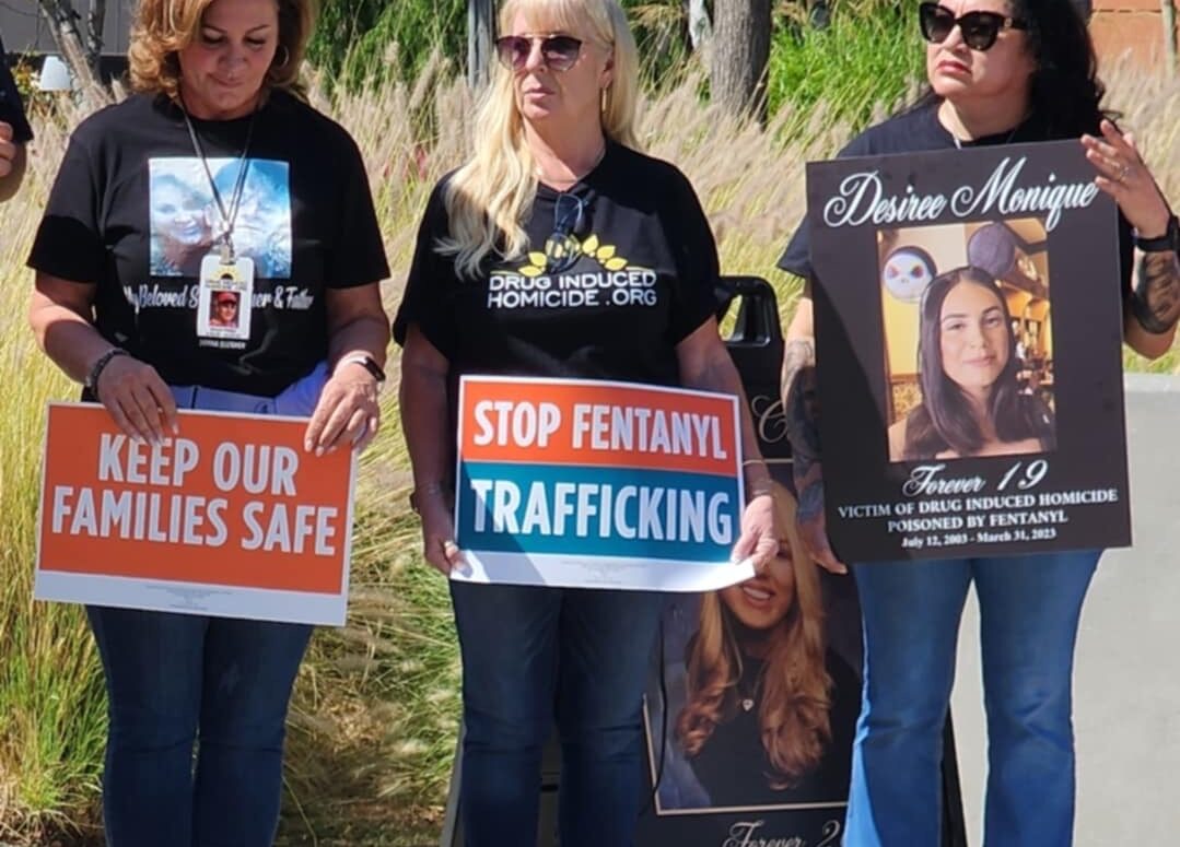 Three women hold signs opposing fentanyl.