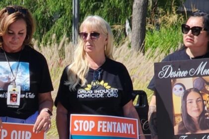 Three women hold signs opposing fentanyl.