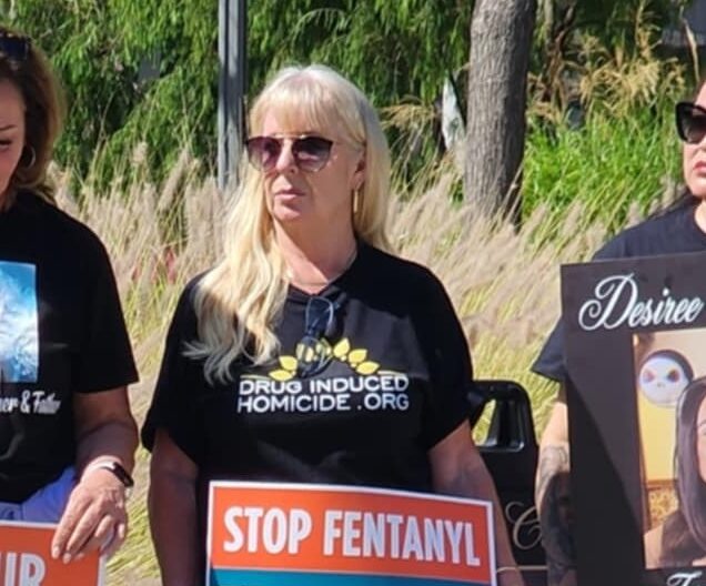 Three women hold signs opposing fentanyl.