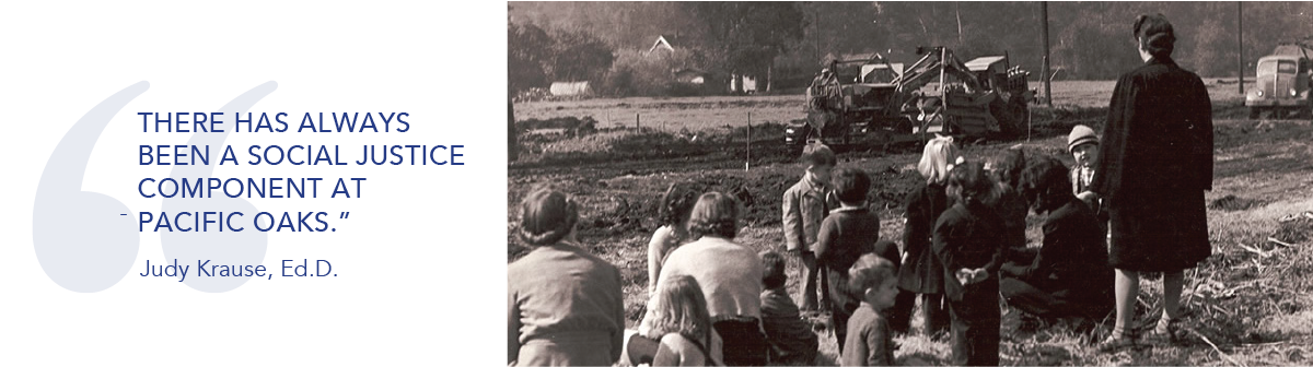 Black and white photo of children and adults standing with construction equipment in background.